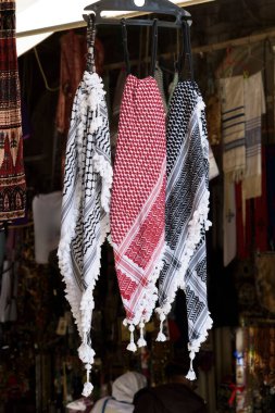 The keffiyeh or kufiyyeh, a traditional headdress worn by men from parts of the Middle East, in a market stall in the Middle East.  clipart