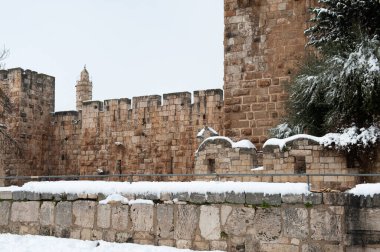 Following a light winter storm in Jerusalem, snow collects along the walls beside the prominent Tower of David citadel in the Old City.  clipart