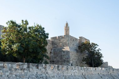 View of the landmark, stone Tower of David and the surrounding walls and greenery of the Old City of Jerusalem.  clipart