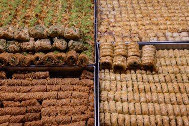 Trays of baklava, a layered pastry dessert made of filo pastry, filled with chopped nuts, and sweetened with syrup or honey, on sale in the Machane Yehuda market in Jerusalem.  clipart