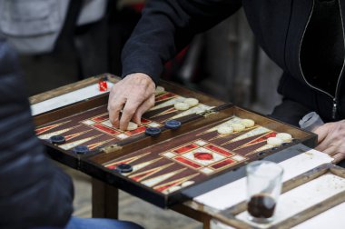 Yaşlı bir adamın eli tavla tahtasında tüm parçaları hareket ettiriyor.. 