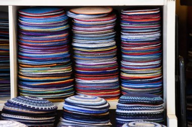 Stacks of colorful, knitted yarmulkes, Jewish skullcaps, in a Judaica store in Jerusalem, Israel. clipart