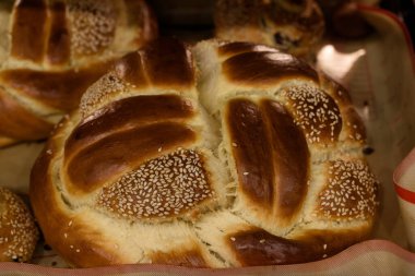 Taze pişmiş, yuvarlak, örülmüş Yahudi bayramında susamlı somun ekmeği.. 