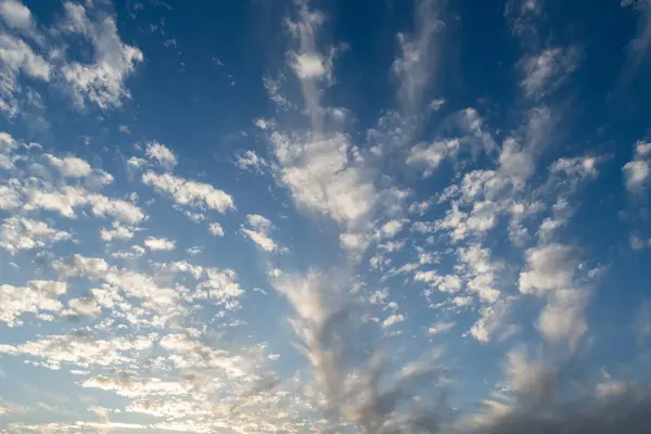 Cirrostratus ya da sirrus bulut oluşumları öğleden sonra güneş ışığında mavi gökyüzüne karşı dizilmiştir.. 