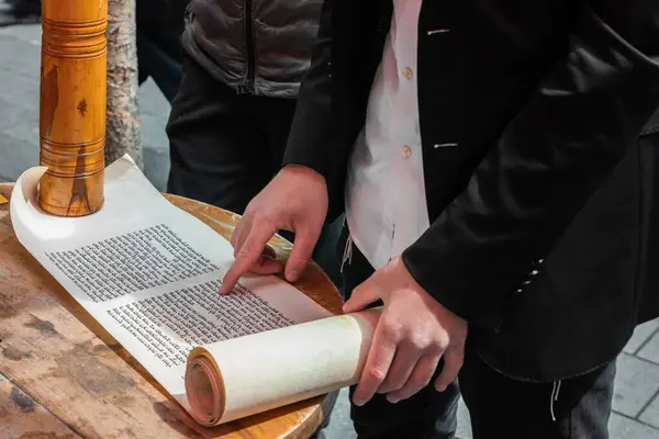 İsrail 'in Kudüs kentindeki Purim bayramında açık bir kafede Esther' in Parşömeni 'nden bir adamın ellerinin yakın çekimi.. 