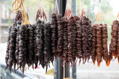 Churchkhela, a popular, traditional, Georgian, candle-shaped candy filled with nuts and fruit, which is dipped in grape must and juices, threaded onto a string and dried in the shape of a sausage. clipart