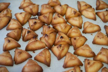 Freshly baked hamantashen, triangular cookies filled with chocolate or jam, traditionally eaten by Jews during the celebration of Purim.  clipart