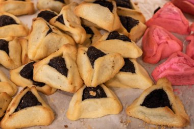 Freshly baked hamantashen, triangular cookies filled with chocolate or jam, traditionally eaten by Jews during the celebration of Purim.  clipart