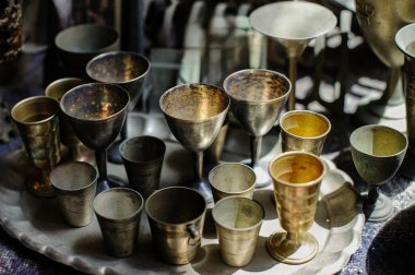 Collection of antique, metal silver kiddush cups traditionally used for reciting the Jewish blessing over wine on the Sabbath and festivals.  clipart