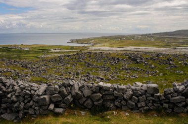Batı İrlanda 'nın Aran Adaları' ndan biri olan Inishmore 'un çorak ve kıyı manzarasını taş dantel duvar çerçeveler.. 