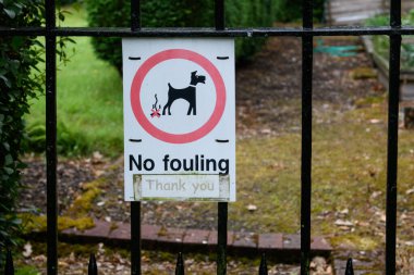 İskoçya 'da halka açık bir parkın önündeki metal kapıya renkli bir tabela asılmış. Köpek sahiplerine evcil hayvanlarının arkasını temizlemelerini hatırlatıyorlar.. 
