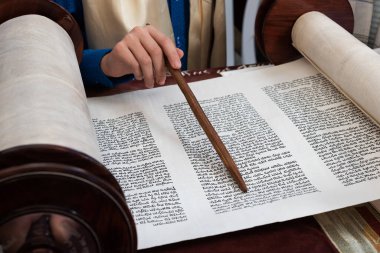 Tevrat okuyucusuna İbranice metinde rehberlik etmek için bir yad ya da işaretçi tutan elin yakınlaştırılması.