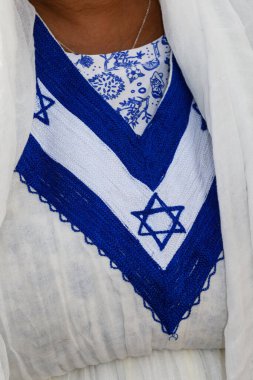 Geleneksel Etiyopya kemerinin ayrıntıları, renkli işlemeli beyaz bir elbise, burada da kadınlar tarafından Kudüs, İsrail 'deki Yahudi bayramında giyilen Davud' un mavi Yahudi yıldızı var.. 