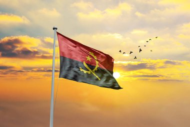 Angola bayrağını gün batımına ya da gündoğumuna karşı sallıyor. Cumhuriyet Günü ve Bağımsızlık Günü için Angola bayrağı.