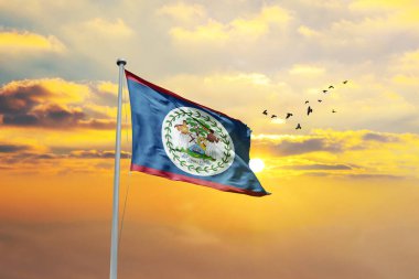 Belize bayrağını gün batımına ya da gündoğumuna karşı sallıyor. Cumhuriyet Günü ve Bağımsızlık Günü için Bayrağı Belize Et.