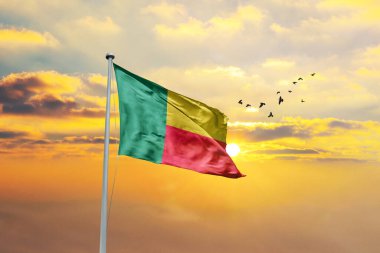 Gün batımına ya da gündoğumuna karşı Benin bayrağı sallıyor. Cumhuriyet Günü ve Bağımsızlık Günü için Benin bayrağı.