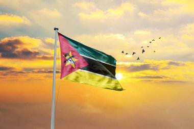 Gün batımına ya da gündoğumuna karşı Mozambik bayrağı sallıyor. Cumhuriyet Günü ve Bağımsızlık Günü için Mozambik bayrağı.