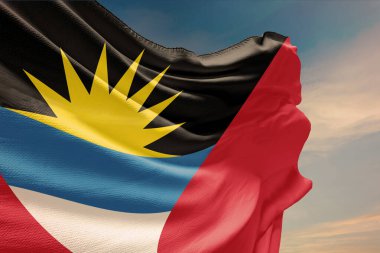 Antigua ve Barbuda 'nın mavi gökyüzünde dalgalanan bayrağı. Bağımsızlık Günü 'nde Antigua ve Barbuda bayrağı direğe asılacak. Devletin dalgalı kumaş üzerindeki sembolü..