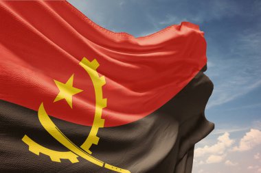 Mavi gökyüzünde Angola bayrağı sallıyor. Angola bayrağı Bağımsızlık Günü için direkte. Devletin dalgalı kumaş üzerindeki sembolü..