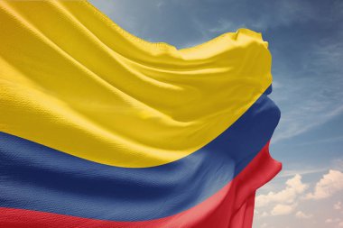 Mavi gökyüzünde Kolombiya bayrağı sallıyor. Bağımsızlık Günü için kutupta Kolombiya bayrağı. Devletin dalgalı kumaş üzerindeki sembolü..