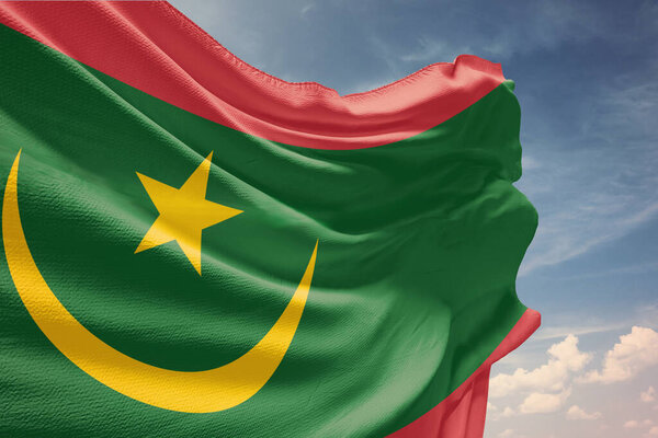 Размахивая флагом Мавритании в голубом небе. Флаг Мавритании на шесте в честь Дня Независимости. Символ государства на волнистой ткани.