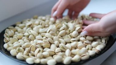 Kırık Kabuklu Kurutulmuş Fıstık ve Yeşil Çekirdekler Yavaş Çekimde Kırsal Seramik Kaseye Düşüyor. Yüksek kalite 4k görüntü