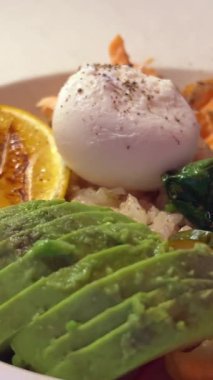 Kırmızı balıklı kase lezzetli yemek haşlanmış limonlu avokado kırmızı soğan turşusu ıspanak lezzetli bir restoranda sunum. Yüksek kalite 4k görüntü