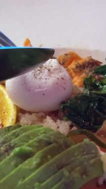 Avokado haşlanmış limonlu yumurta ıspanak soğan, kırmızı balık, pilav, öğle yemeği, bıçak ve çatal yumurtayla kesilmiş. Yüksek kalite 4k görüntü