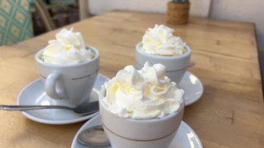 France Cannes 'da. Üç kupa kremalı kahve, ahşap bir masaya dekore edilmiş. Bir saksı koy, fotoğraf çek, turistler seyahat etsin, sıcak içecekler iç.