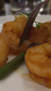 Kızarmış karides yiyorum. Kızarmış karides tabağı, kapat. Karanlık bir restoranda, karidese çatal saplıyor, Meksika yemeği.