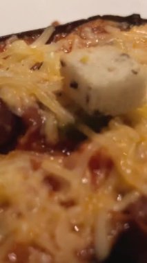 Fırında pişirmeden önce peynirle serpiştirilmiş domates, biber, soğan ve şampiyon mantarlarıyla doldurulmuş patlıcanlar, yakın çekim, yavaş çekim. Sağlıklı beslenme. peynirli fırında patlıcan