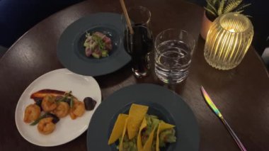 Meksika guacamole ve tortilla cipsi, nachos, yavaş dönen kameranın üst görüntüsü, ulusal tatiller için tipik yemek, cinco de mayonez. Karides ve ton balığı.