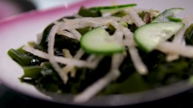 Bir kasede yosun uyandır. Asya mutfağı yemek malzemesi. Masa dönüşü. Salatalıklı yosun