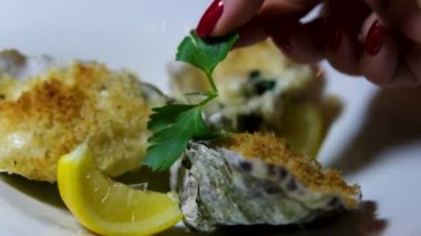 Limon dilimleri ve süslerle servis edilen istiridyeler. Doldurulmuş istiridye maydanozla süslenmiş.