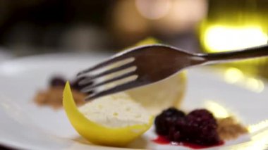 Tabakta bir çatalla limonlu cheesecake yiyorum. Yüksek kalite 4k kalite ayaklı kek biçimli limonlu cheesecake