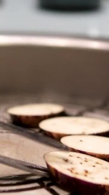 Mor patlıcan kızartması fırının tepesindeki ızgara tavada pişirme yağında dilimlenir. Yüksek kalite 4k görüntü