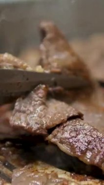 Izgara pastırma şeritleri cızırdayan iyiliğin özünü yakalar ve yok edilmeye hazırdır. Izgara domuz pastırması, yakın plan. Klasik, dumanlı ve çıtır pastırma. Yüksek kalite 4k görüntü