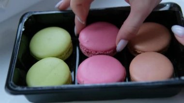 Cam üzerine ışık yansıtan, sarı, yeşil ve beyaz badem kurabiyelerinin sergilendiği bir vitrine yerleştirilmiş çeşitli renkli badem kurabiyelerinin yakın çekimi. Yüksek kalite 4k görüntü