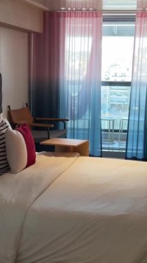 Kabin aynası yastıklar temiz battaniye odası balkon aynalı telefon masası iki kamara balkon yolcu gemisi Virgin Voyages için rahat bir yer. İspanya Barselona 11.2024 