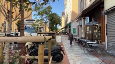 Napolyon 'un doğduğu yer Napolyon Caddesi Motosiklet Kafe' si. Çok az insan esintisiz hava durumu sunan kadınlar Korsika Adası açıklarında kapalı dükkanların önünden geçiyor. Fransa Ajaccio 11.2024