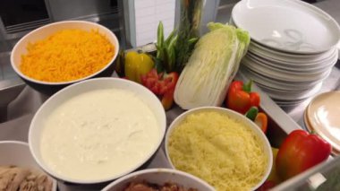 Yemek pişirme patatesleri çeşitli malzemeler domates dilimleme avokado ton balığı et seçimi bir büfede. Sandviç yapmak için gerekli malzemeler.