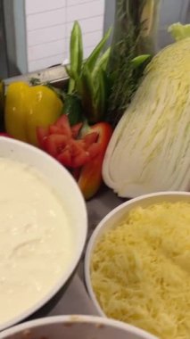 Yemek pişirme patatesleri çeşitli malzemeler domates dilimleme avokado ton balığı et seçimi bir büfede. Sandviç yapmak için gerekli malzemeler.