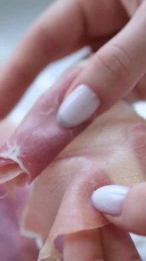 Jamon jambonlu kadın elleri, ince dilimler halinde dilimlenmiş domuz pastırması dilimleyen lezzetli bir et parçasına sarılmış. Yüksek kalite 4k görüntü