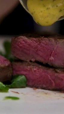 Yemek videosu yavaş çekimde. Fırfırlı bifteğe sos döken şef. Restoran yemeği servisi. Ağır çekimde akıcı soslu ızgara barbekü dana eti. - Evet. Yüksek kalite 4k görüntü