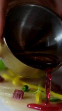 Çiğ balık Carpaccio 'nun üzerine tartar sosu dök. Ton balığı. Kadın taze limon suyunu siyah seramik tabakta taze çiğ ton balığı filetosuna sıkıyor. Yüksek kalite 4k görüntü