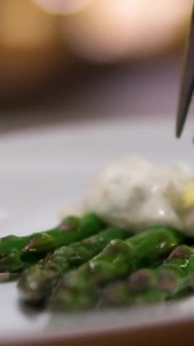 Bifteğe kuşkonmaz ve siyah tabakta bir dilim limon restoranda bir garson tarafından getiriliyor. Yakın çekimde gerçek zamanlı el kamerası. Yüksek kalite 4k görüntü