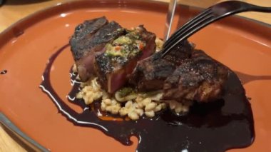 Şef taze ızgara et dilimliyor. Mutfaktaki ahşap kesme tahtasının üzerinde bıçakla. Yemekler yakınlaştırılıyor. Yüksek kalite 4k görüntü