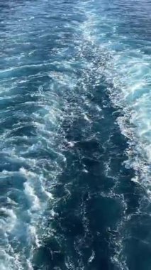 Beyaz dalga köpüğü ve gemi kabarcıkları denizde ya da okyanusta hareket eder. Gün batımında tekne üstüne tekne. Yüksek kalite 4k görüntü