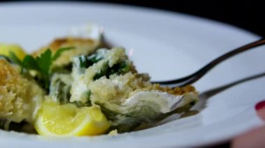 Yakın planda çatalla yemek yiyen bir kadın buzun içinde yeni açılmış istiridyeler. İstiridye ve taze sıvı yarım kabuk konsepti, 4K 'da deniz ürünleri. Yüksek kalite 4k görüntü