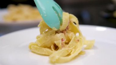 Kamera, masada servis edilen Carbonara makarnasını takip ediyor. Yüksek hızlı kamera ve hayalet kaslı 4K ile çekilmiş. Ağır çekim. Yüksek kalite 4k görüntü